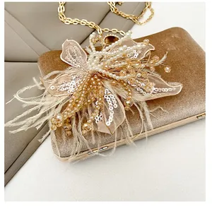Macro detail of elegant evening bag featuring intricate pearl and feather floral décor