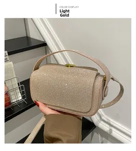Detailed view of light gold evening box bag with shimmering rhinestones and metal accents
