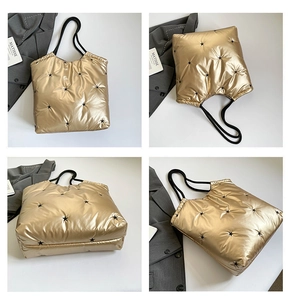 Detail view of gold quilted tote bag with black star embroidery and rope handles
