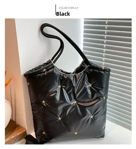 Detail of black puffer tote bag with gold star embroidery and soft quilted texture
