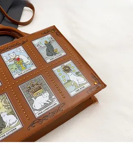 Close-up of cat tarot illustrations and metal rivets on brown vintage tote bag