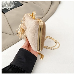 Detail view of champagne velvet evening bag with crystal ring clasp and pearl tassels