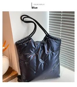 Close-up of blue quilted tote bag with star embroidery and rope handle detail