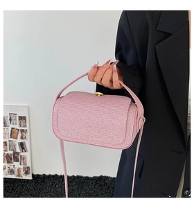 Detail of pink pearlescent mini box bag with sparkling texture and gold hardware