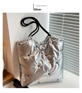 Detailed view of silver metallic tote bag with black stars and thick rope handles