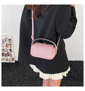 Pink glitter crossbody box bag with metallic texture shown on a female model