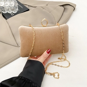 Detail of champagne velvet clutch with a sparkling rhinestone ring clasp and gold chain