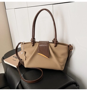 Detail of khaki pleated handbag with brown handle and golden metal clasp decoration