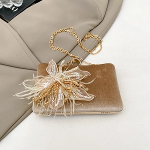 Detail of champagne velvet clutch with 3D handmade floral, pearl and feather embellishments