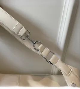 Detail of silver hardware and stitching on off-white leather dumpling shoulder bag