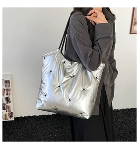 Silver metallic padded tote bag with black star embroidery and long shoulder straps