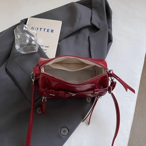Deep red glossy patent leather pillow bag with silver buckles and fabric lining