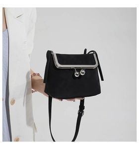 Detailed view of black retro suede crossbody bag with vintage silver metal clasp closure