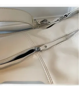 Detail of vintage beige shoulder bag showing smooth metal zipper and neat stitching