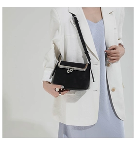 Close-up of vintage black crossbody bag with metal frame clasp and adjustable strap