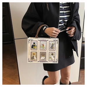 Close-up of bohemian tote bag featuring cat tarot card illustrations and gold rivet details