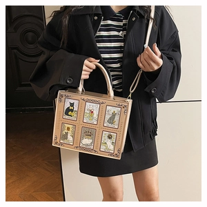 Detail of beige tote bag featuring cute cat tarot card prints and adjustable strap