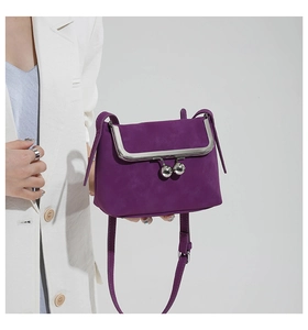 Detail of vintage purple shell crossbody bag with silver clasp on a white suit model