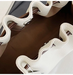 Detail of lychee pattern leather bag with magnetic buckle and brown drawstring closure