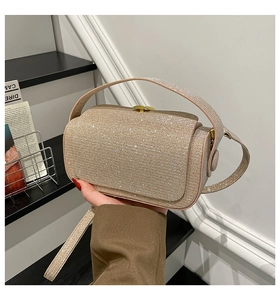 Detailed close-up of champagne gold sequined evening box bag with metallic clasp and strap