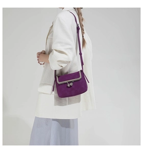 Close-up of deep purple suede crossbody bag with vintage metal frame and kiss-lock closure