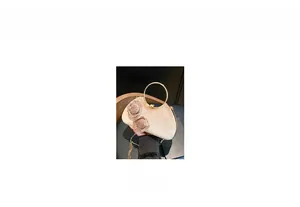 Detail of champagne evening bag with 3D rose decor and round metal top handle