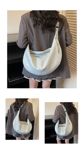 Detail of mint green glossy crescent bag with wide adjustable strap and zipper details
