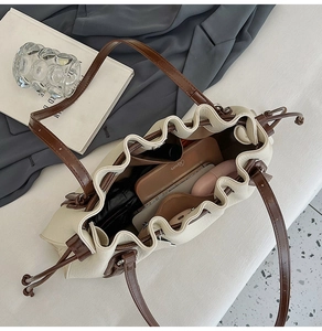 Interior view showing the large capacity of the drawstring bucket bag with daily items