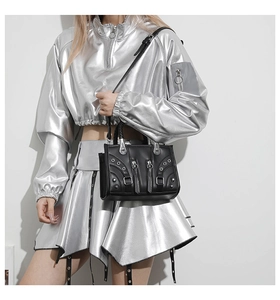 Detail of black punk leather handbag with silver rivets and studs on a silver jacket model