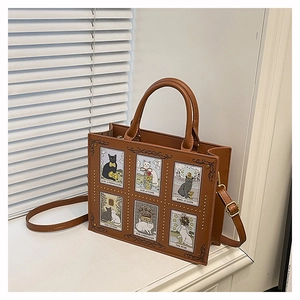 Macro detail of cat tarot prints and golden studs on brown leather tote handbag