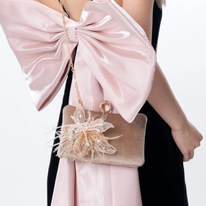 Detail of luxury velvet evening bag with 3D floral embellishments and gold chain strap