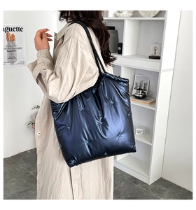 Detailed close-up of navy blue puffer tote bag with star embroidery and rope handle