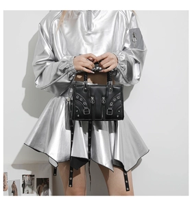 Detail of black punk style handbag with silver zippers and metal eyelet decorations
