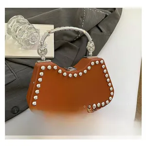 Detail of vintage brown box bag with silver studs and an arched metal handle