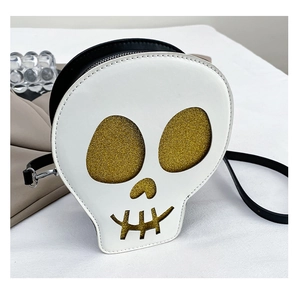 Macro detail of skull-shaped crossbody bag featuring gold glitter eyes and black leather trim