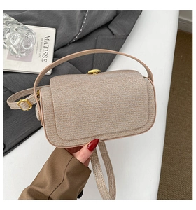 Detailed close-up of champagne gold glitter crossbody bag with metallic strap buckles