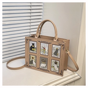 Close-up of cat tarot card illustrations and gold rivets on leather tote bag