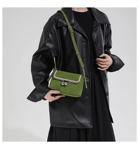 Detail of vintage grass green leather shell bag with silver clasp and adjustable strap