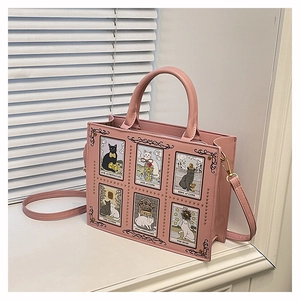 Detail of pink PU leather tote featuring cat tarot card prints and gold rivet accents