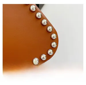 Macro shot of brown leather texture with silver rivet studs detail and premium finish
