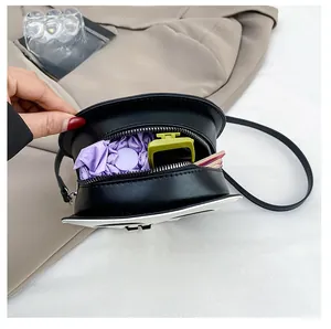 Interior view of black skull crossbody bag showing capacity for small umbrella and cosmetics