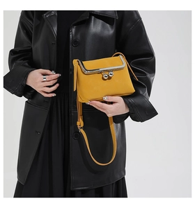 Detail of yellow vintage kiss-lock crossbody bag with silver frame and litchi texture