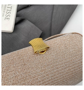 Close-up of champagne gold glitter fabric and fan-shaped metal lock on the evening bag