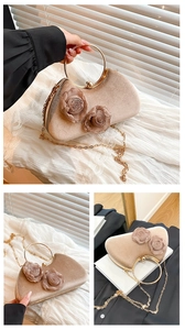 Detail of beige velvet clutch bag featuring 3D fabric roses and golden ring handle