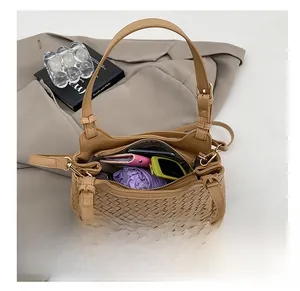 Vue intérieure du sac seau tressé marron clair montrant sa grande capacité et son contenu