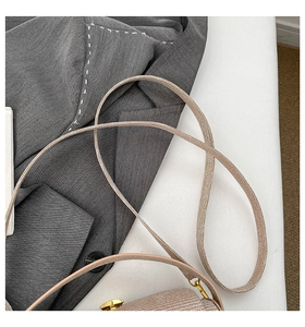 Detailed close-up of champagne gold crossbody bag with metallic texture and strap