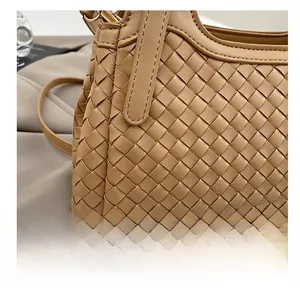 Détail macro de la texture en cuir tressé et coutures précises sur la poignée