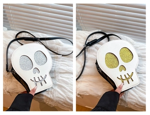 Detail of skull-shaped crossbody bags featuring glitter accents in silver and gold colors