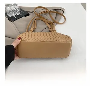 Détail du sac à bandoulière tissé kaki montrant la base plate et la sangle assortie