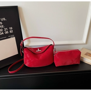 Detail of red suede dumpling bag with metal twist lock and matching zipper pouch